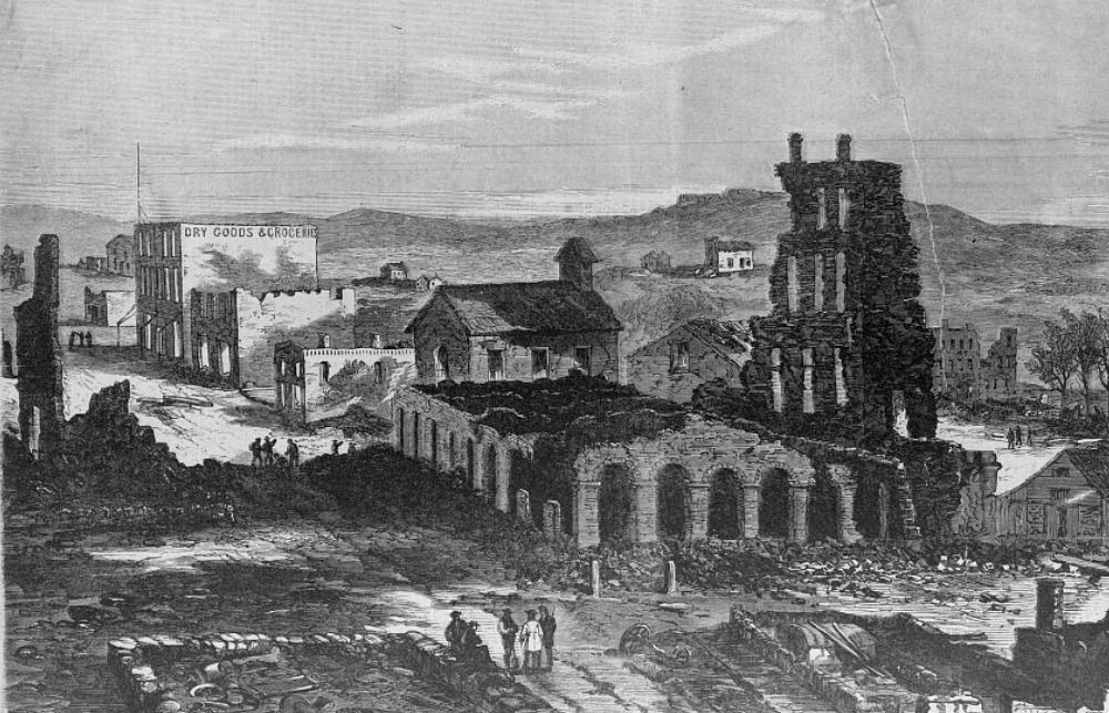 Lawrence in ruins as illustrated in Harper's Weekly. The charred remains of the Eldridge House are in the foreground.