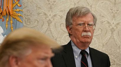 National Security Adviser John Bolton standing behind President Trump in April. Photo credit: Getty Images