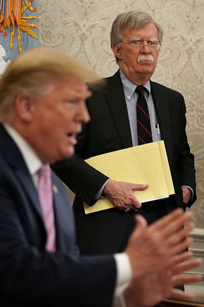 National Security Adviser John Bolton standing behind President Trump in April. Photo credit: Getty Images