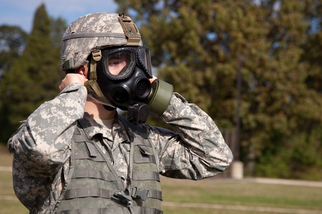 Soldier donning a gas mask.