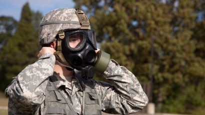 Soldier donning a gas mask.