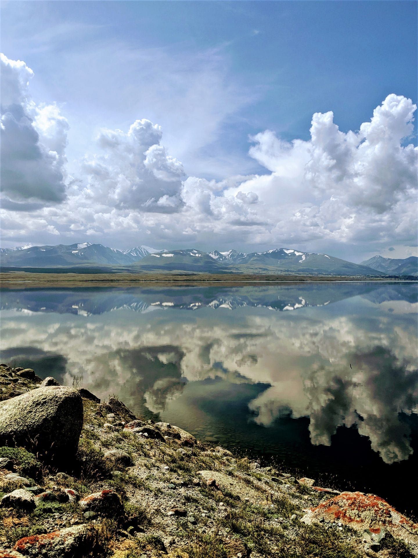 The Altai Mountains reflect off of Khurgan Nuur, a lake formed after the recession of glaciers thousands of years ago left a huge hollow that then filled with glacial melt.