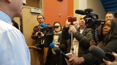politician facing cameras and microphones