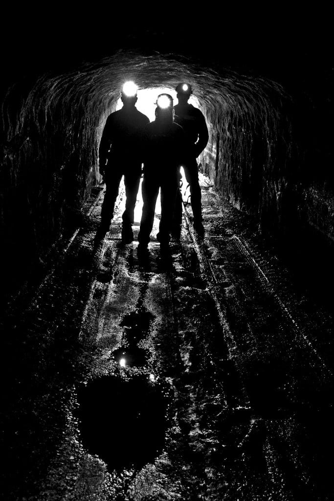 coal miner silhouettes lit by headlamps