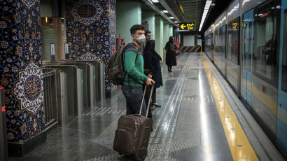 Passengers wait for the train with masks on.