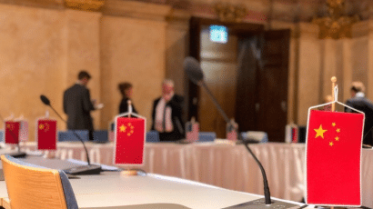 A small Chinese flag placed in front of an empty chair.