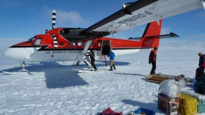 bright red-and-white plane on Antarctic ice