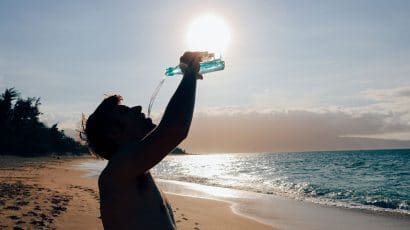 silhouette man drinking water on beach