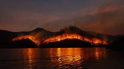 wildfire on mountain reflected in lake