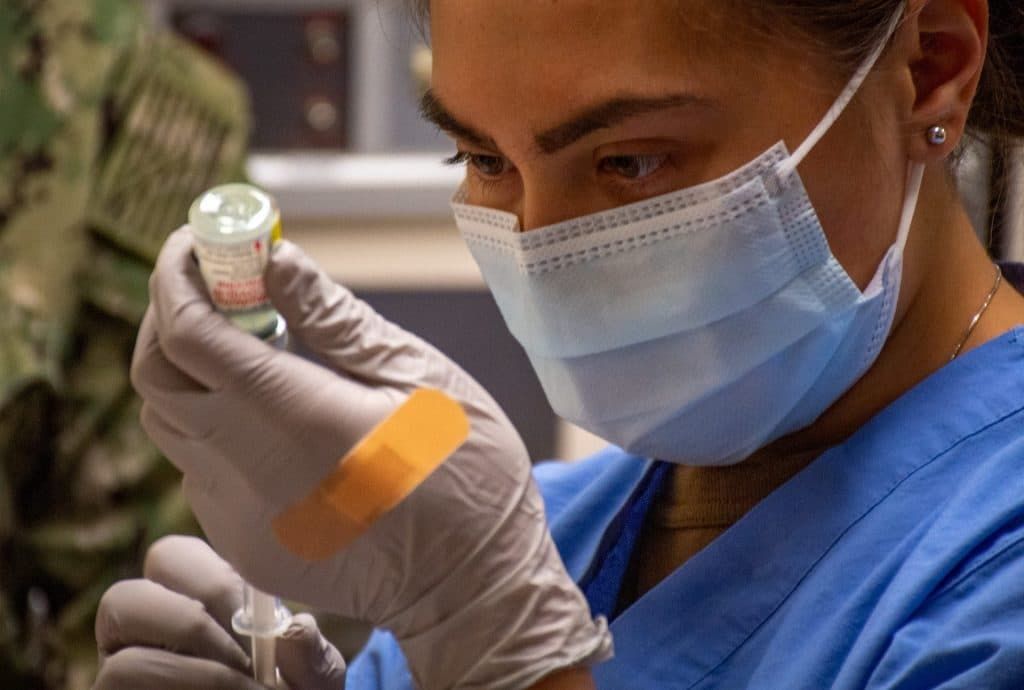 A health care worker prepares a COVID-19 vaccine.