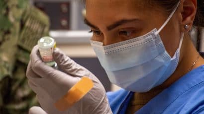 A health care worker prepares a COVID-19 vaccine.