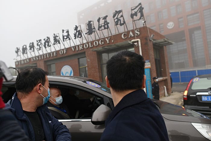 Leden van het team van de Wereldgezondheidsorganisatie (WHO) die de oorsprong van het COVID-19-coronavirus onderzoeken, arriveren op 3 februari met de auto bij het Wuhan Institute of Virology (Foto door HECTOR RETAMAL/AFP via Getty Images)