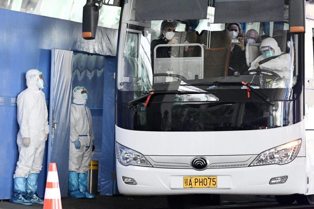A bus carrying a team of experts from the World Health Organization departs an airport in Wuhan on Jan. 14, 2021, after arriving in the Chinese city to investigate the origins of the coronavirus pandemic. That investigation is widely seen as having been obstructed by Chinese authorities. (Photo by Kyodo News via Getty Images)