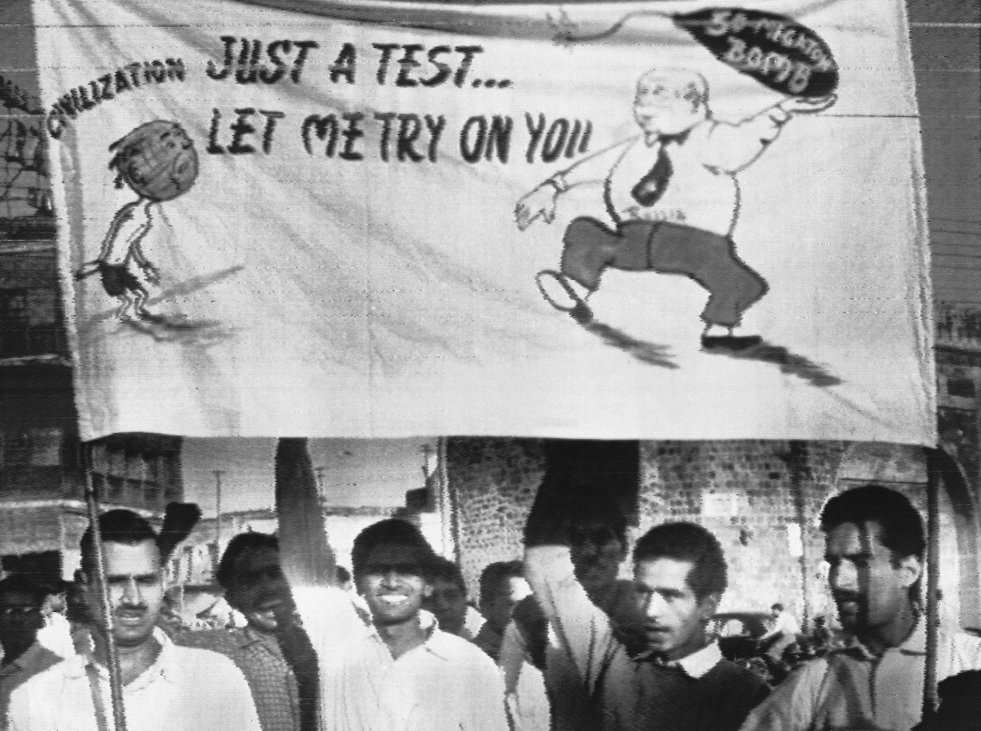 Demonstrators raise a poster during protest processions near the Soviet Embassy in New Delhi, India on November 1, 1961. The poster depicts Soviet Premier Nikita Khrushchev throwing a 50-megaton nuclear bomb on civilization. Lettering reads, "Just a test... let me try on you." (AP Photo)