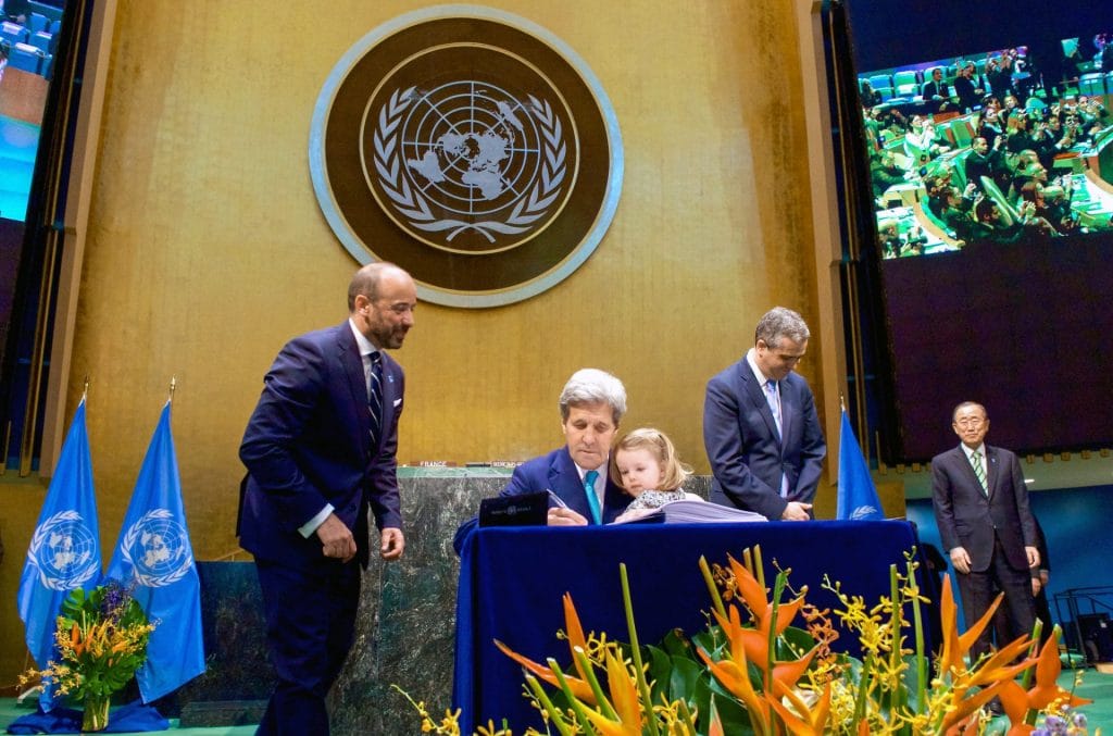 U.S. Secretary of State John Kerry, with his two-year-old granddaughter Isabelle Dobbs-Higginson on his lap signs the COP21 Climate Change Agreement on behalf of the United States