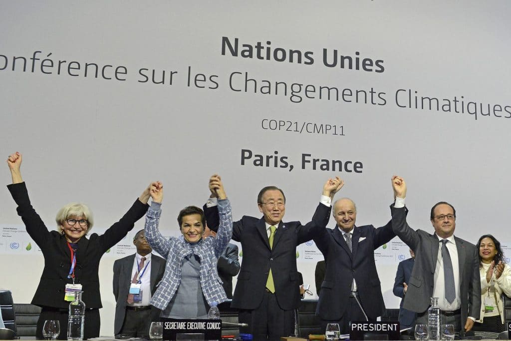 World leaders celebrate with hands up after signing Paris climate accords at COP21