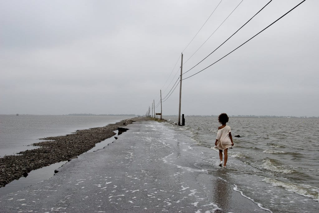 school child walking down flooded road in Gulf of Mexico