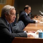 Secretary-General António Guterres seated at a table, addressing a conference