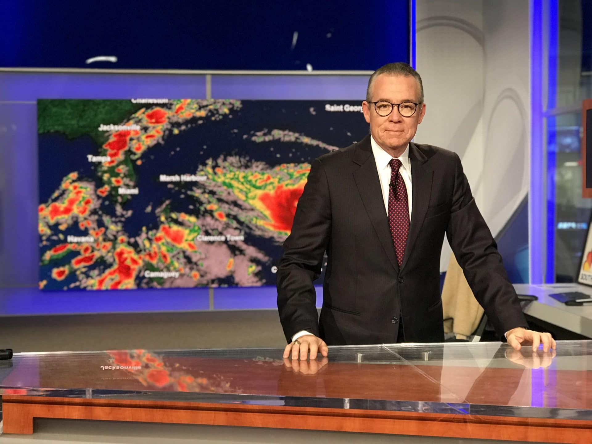broadcast meteorologist standing in front of a map