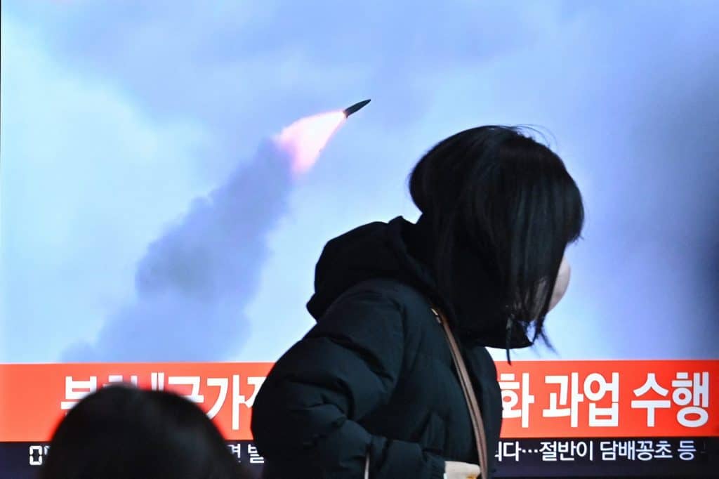 People walk past a television screen showing a news broadcast with archival footage of a North Korean missile test, at a train station in Seoul on January 11, after North Korea fired a "suspected ballistic missile" in the sea, the South Korean military said, less than a week after Pyongyang reported testing a hypersonic missile.  (Photo by Anthony Wallace/AFP via Getty Images)