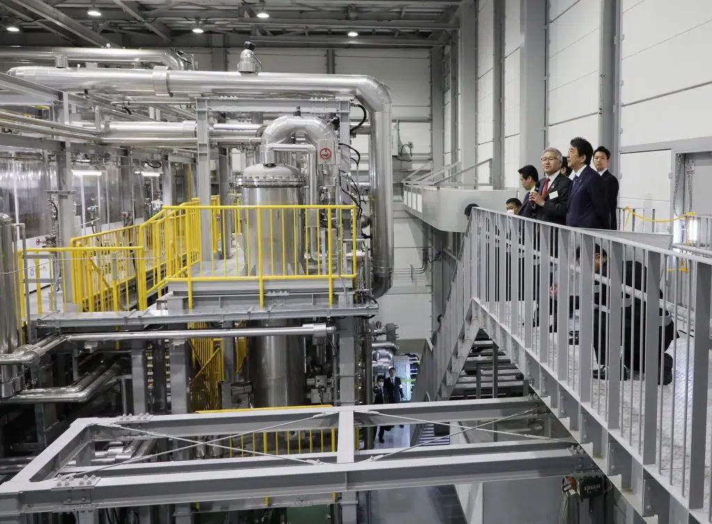men standing on platform and looking at industrial equipment