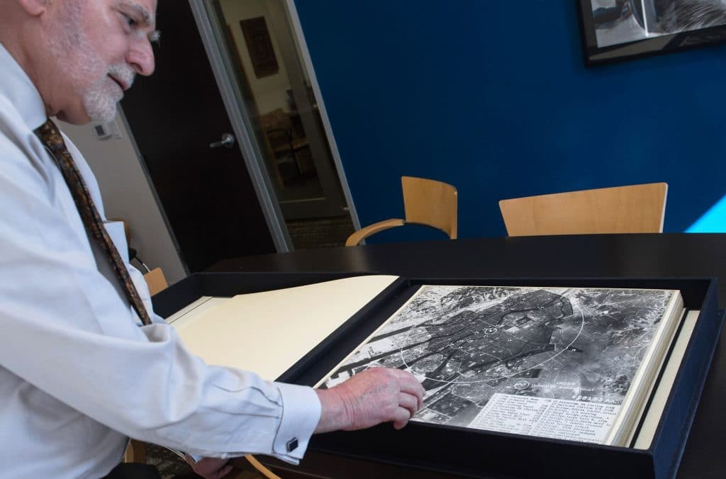 Michael Krepon, co-founder of the Stimson Center think tank, shows an aerial picture taken by the US military in the days after the first atomic bomb was dropped on Hiroshima on August 6, 1945. The institution later gifted the photos to the Hiroshima Peace Memorial Museum. (Photo credit: NICHOLAS KAMM/AFP via Getty Images)