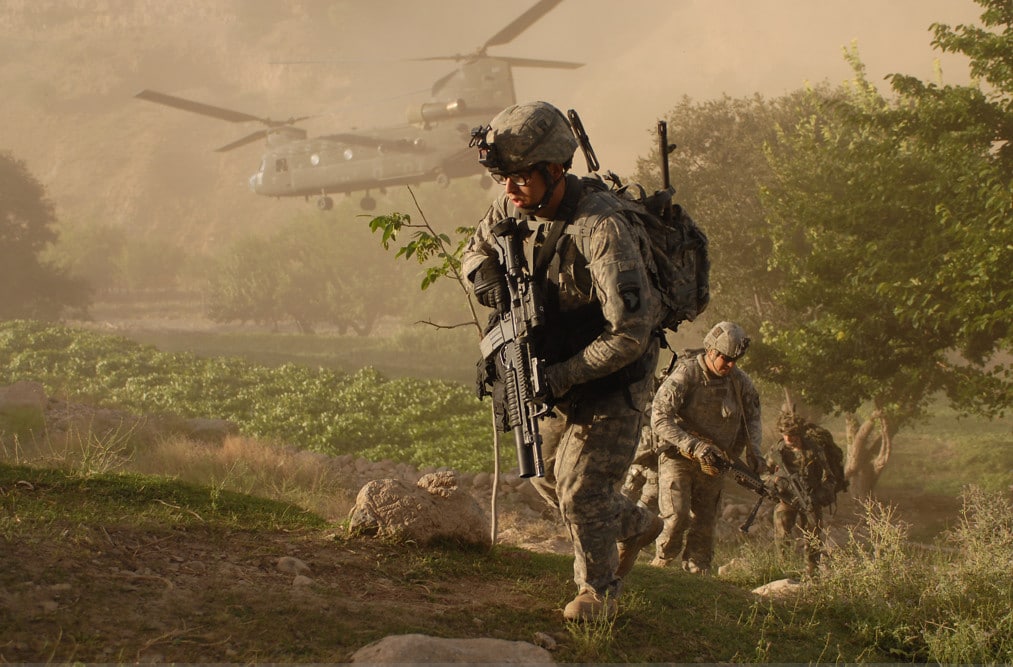 army soliders with a helicopter in the background