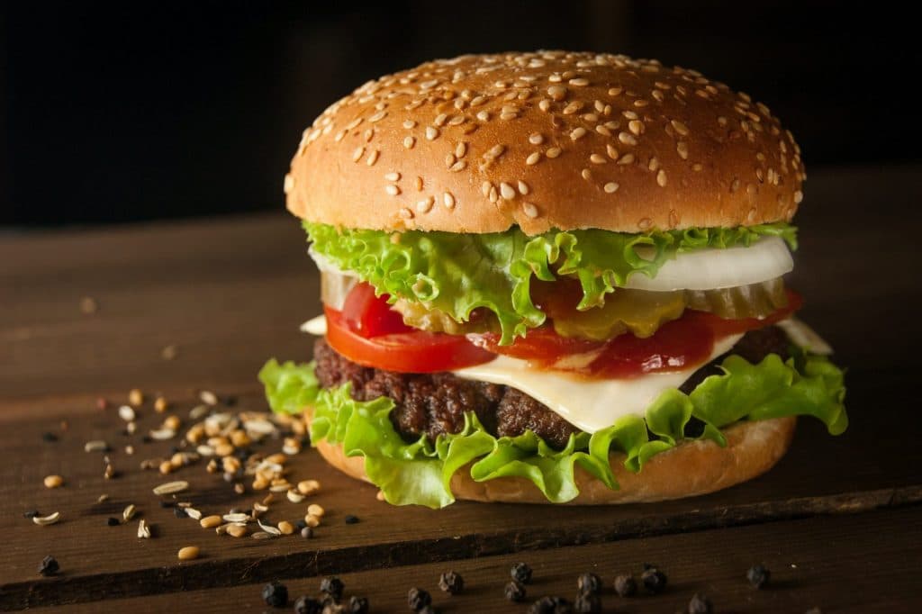 a cheeseburger with lettuce and tomato