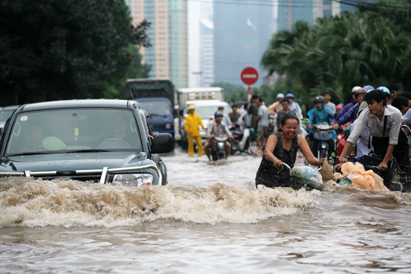 drivers and bikers make their way through flooded streets in Hanoi, Vietnam