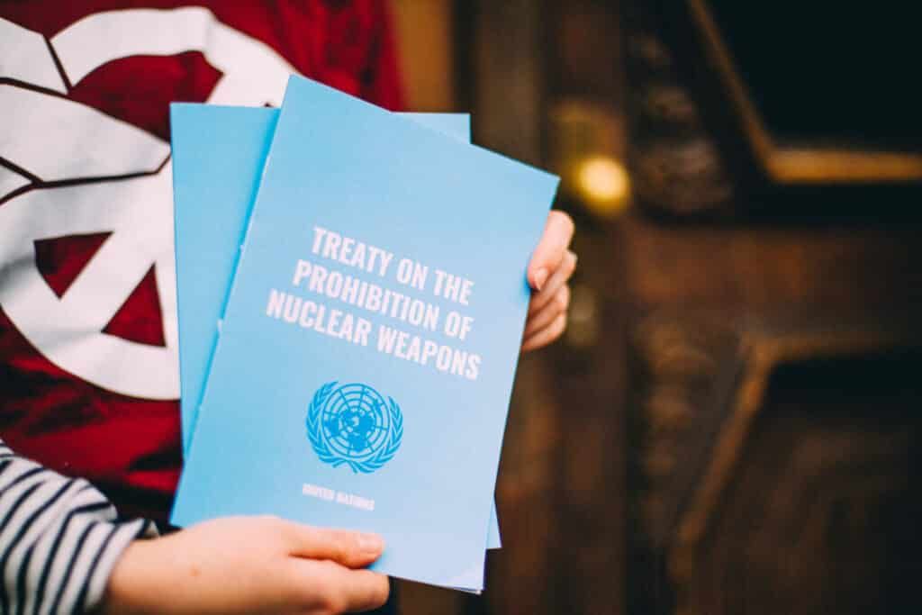 Campaigner holding up a copy of the Treaty on the Prohibition of Nuclear Weapons
