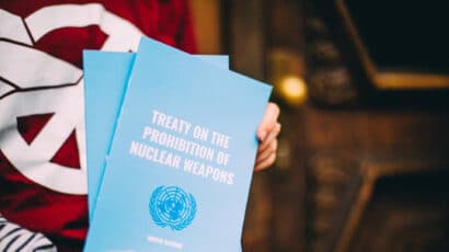 Campaigner holding up a copy of the Treaty on the Prohibition of Nuclear Weapons