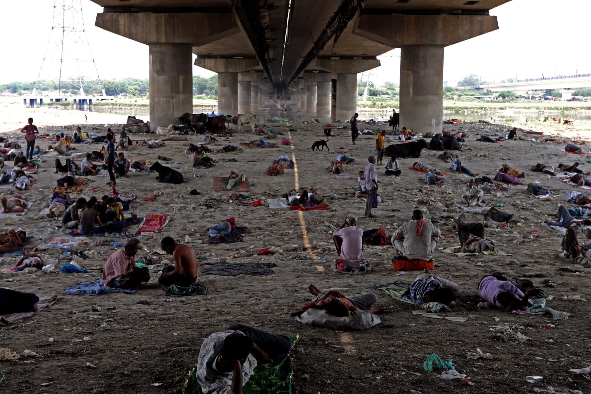 People sheltering from heat under a bridge at the Yamuna River bed in New Delhi on May 10, 2022. (Photo by Amarjeet Kumar Singh/Anadolu Agency via Getty Images)