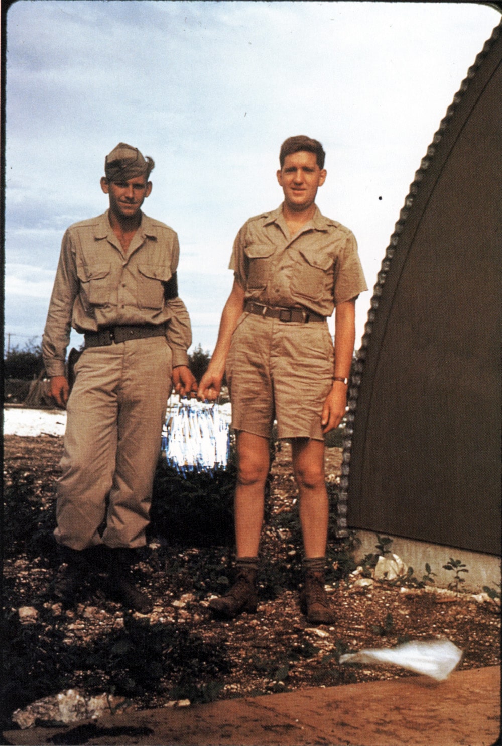 Scientists holding the container with the plutonium core that was to be the heart of the Fat Man atomic bomb. Image taken on the island of Tinian, August 1945. At right is physicist Harold M. Agnew, later to become the director of Los Alamos National Laboratory. The portion of the image showing the container itself had been scratched out by the FBI in 1946, in an effort at secrecy. Now, of course, this photo is declassified, as are all the materials published here. (Agnew also managed to sneak a camera onto Bockscar which was used by one of the crew to take the photos of bomb damage. No one on the plane knew how to operate the official camera because the official cameraman was not on the plane, due to a mishap.) Photo taken by Harold Agnew. Image courtesy of the Los Alamos National Laboratory