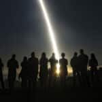 night-time test launch of Minuteman ICBM with silhouettes of crowd
