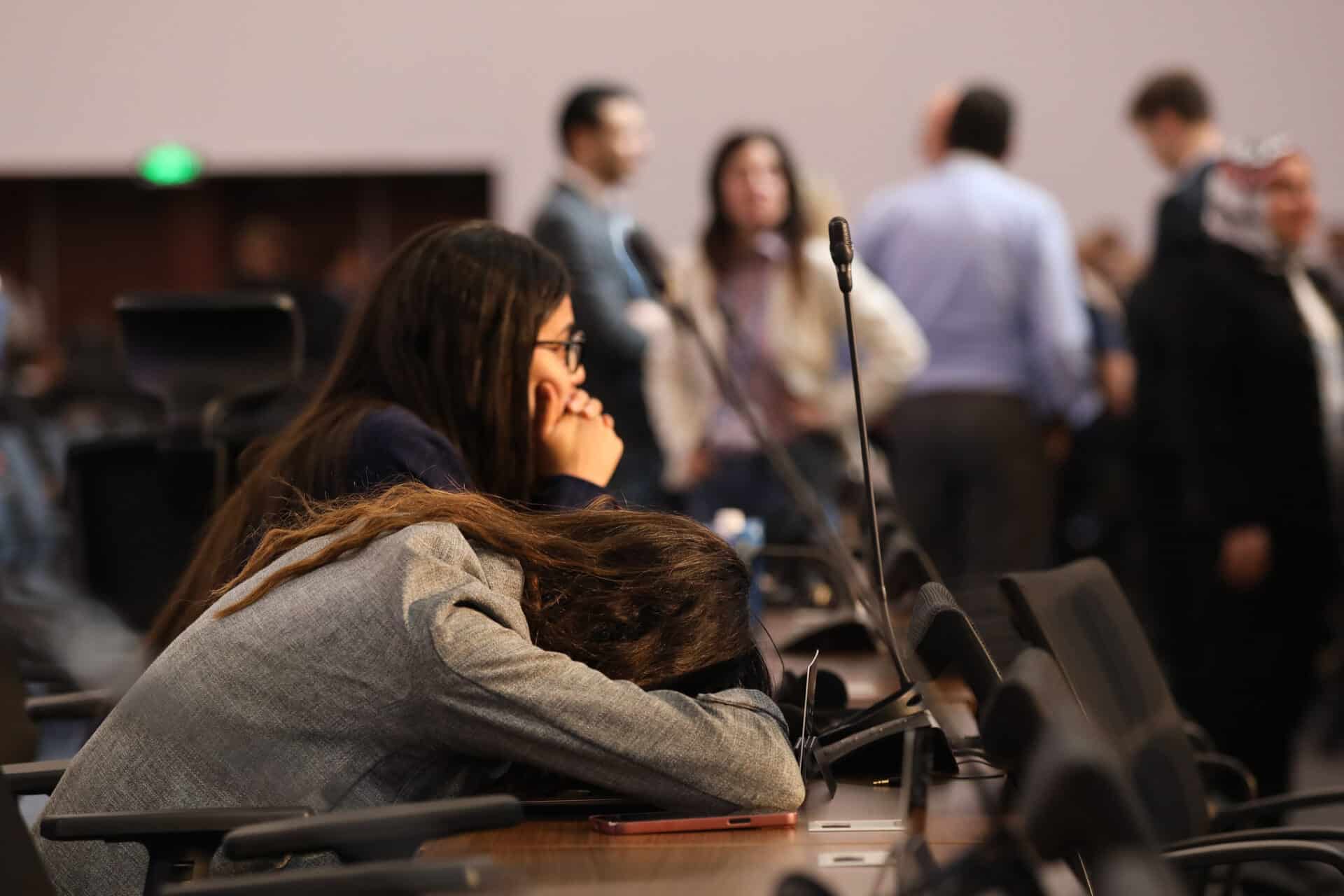 a conference attendee lays her head down on a table