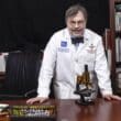 Peter Hotez at his desk in a white physician coat