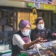 masked women working at a food stall