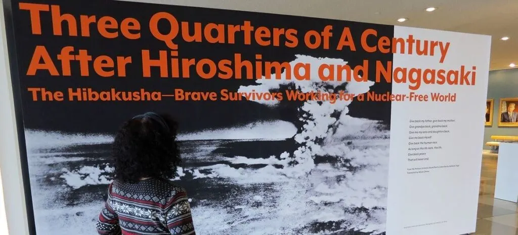 Erico Platt looks at the disarmament exhibition that she staged in 2022, "Three Quarters of a Century After Hiroshima and Nagasaki: The Hibakusha—Brave Survivors Working for a Nuclear-Free World." Photo by UNODA/Diane Barnes.