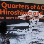 Erico Platt looks at the disarmament exhibition that she staged in 2022, "Three Quarters of a Century After Hiroshima and Nagasaki: The Hibakusha—Brave Survivors Working for a Nuclear-Free World." Photo by UNODA/Diane Barnes.