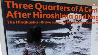 Erico Platt looks at the disarmament exhibition that she staged in 2022, "Three Quarters of a Century After Hiroshima and Nagasaki: The Hibakusha—Brave Survivors Working for a Nuclear-Free World." Photo by UNODA/Diane Barnes.