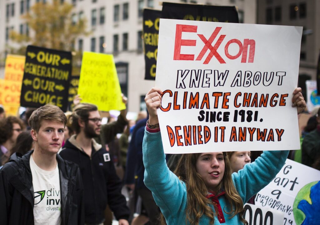 Sign text: Exxon knew about climate change since 1981. Denied it anyway.