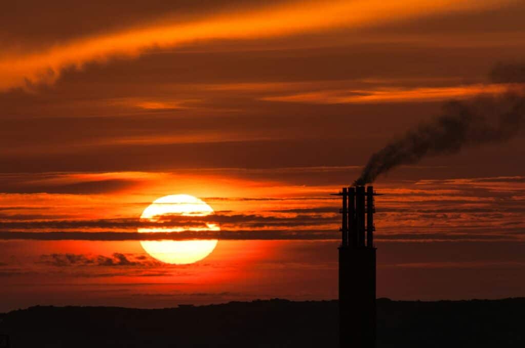 sunset with silhouette of smoke from power station
