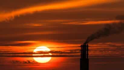 sunset with silhouette of smoke from power station