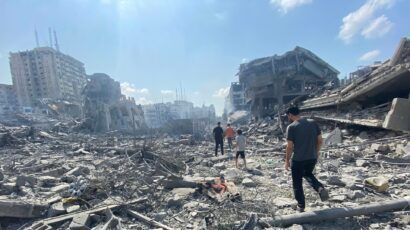 people walking through destruction in Gaza