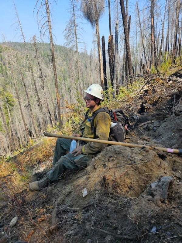 Muhammad Khdair rests near burnt trees during the August 2023 Gold Creek fire in Okanogan County, Washington. (Courtesy Muhammad Khdair)