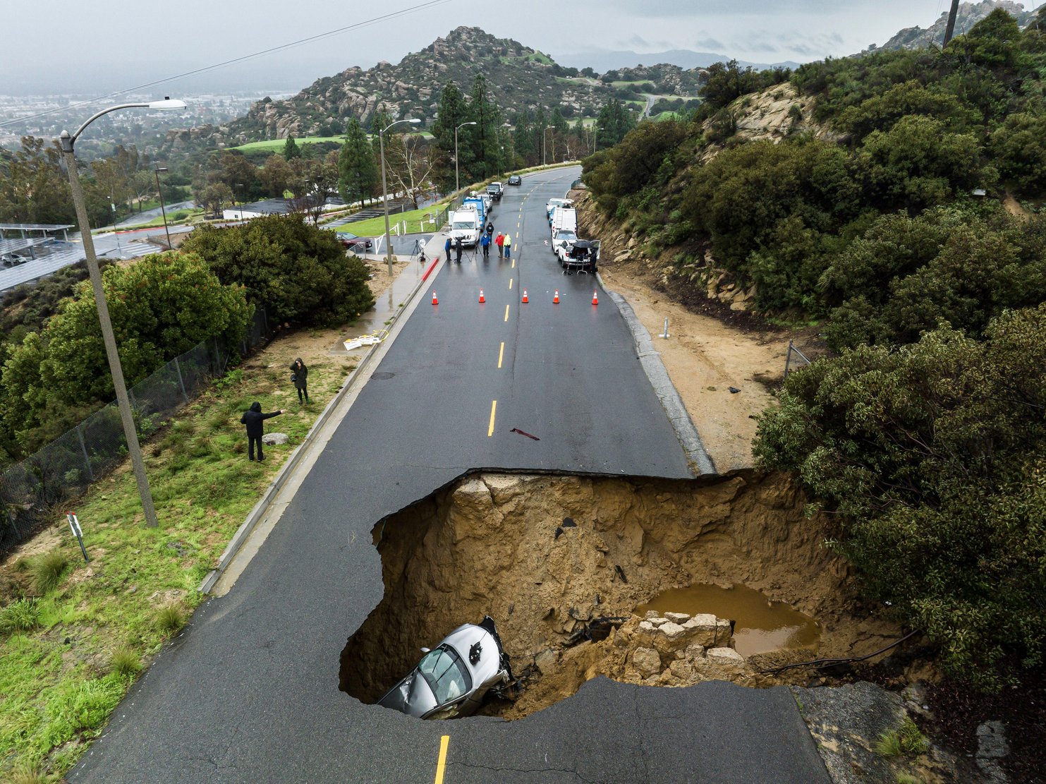After an atmospheric river brought heavy rains in January 2023, a large sinkhole opened up on a road in the Chatsworth area of Los Angeles. (Photo by Ted Soqui / SIPA USA / Alamy) 