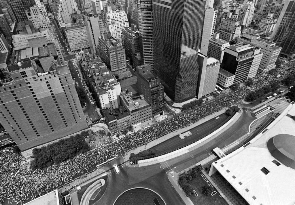 Aerial view of throngs of people passing the United Nations headquarters on their way to a rally against nuclear weapons