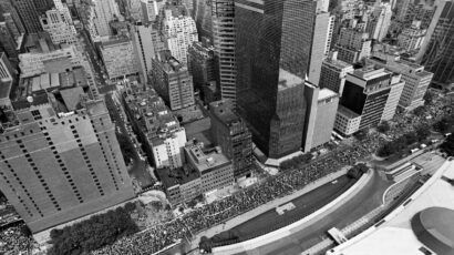 Aerial view of throngs of people passing the United Nations headquarters on their way to a rally against nuclear weapons