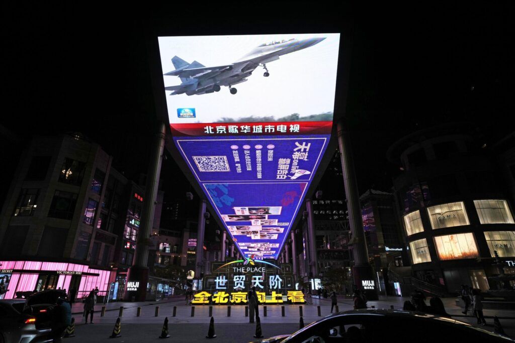 A large screen on a street in Beijing shows a Chinese military plane participating in a three-day air and sea exercise around Taiwan that began on April 8, 2023.