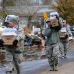 national guard members carry bottle water after hurricane sandy